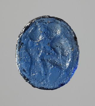 I1100 Siddende våbensmed der arbejder på en hjelm (?)