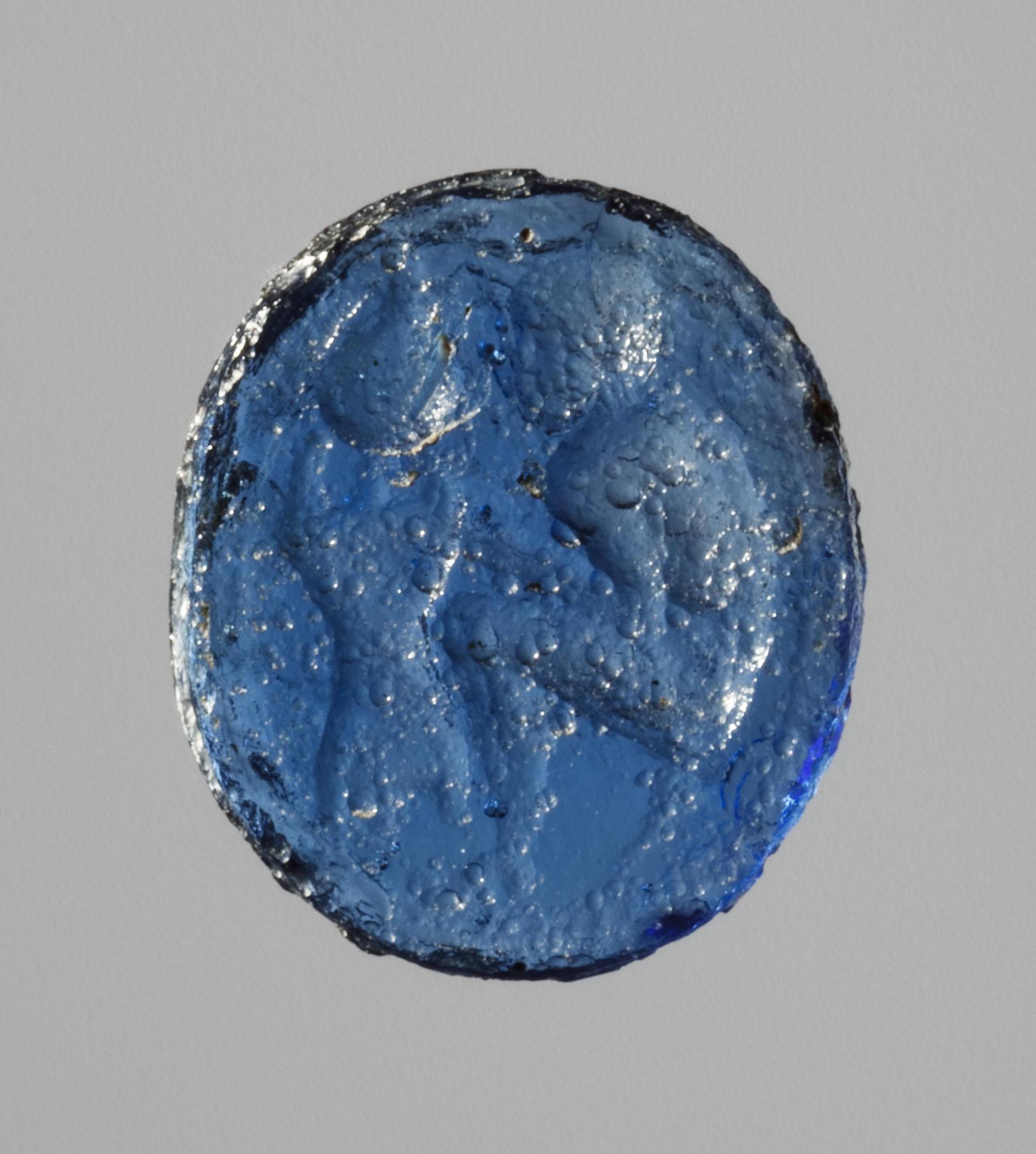 Siddende våbensmed der arbejder på en hjelm (?), I1100