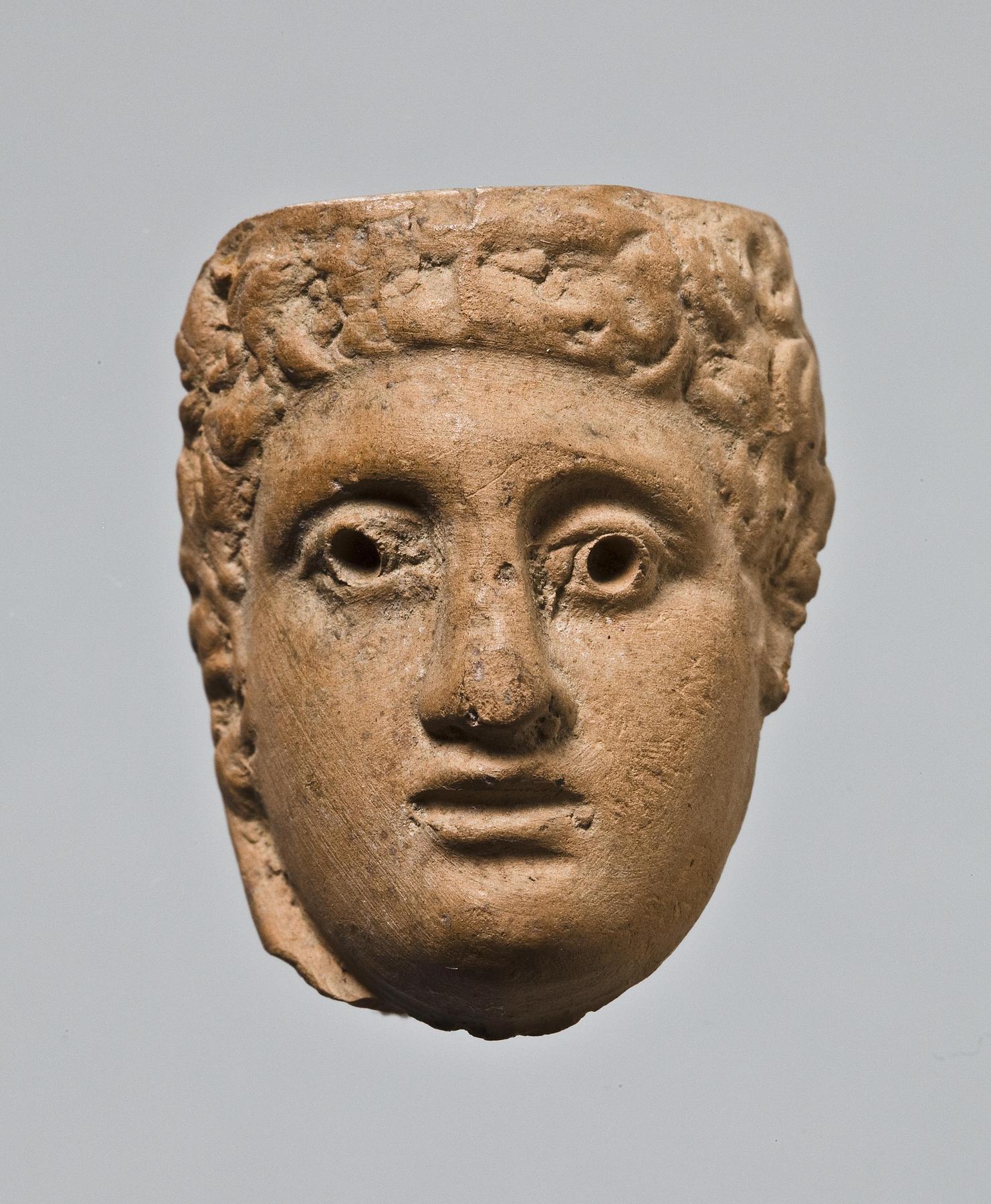 Appliqué (?) in the shape of a male head, H1035