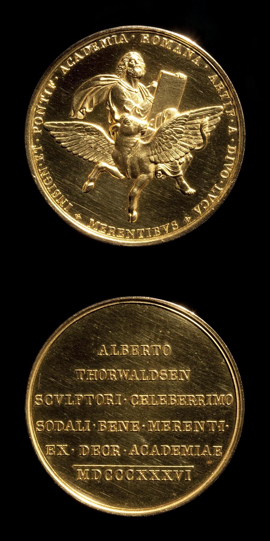 Medaljens forside: Evangelisten Lukas. Medaljens bagside: Indskrift, F8