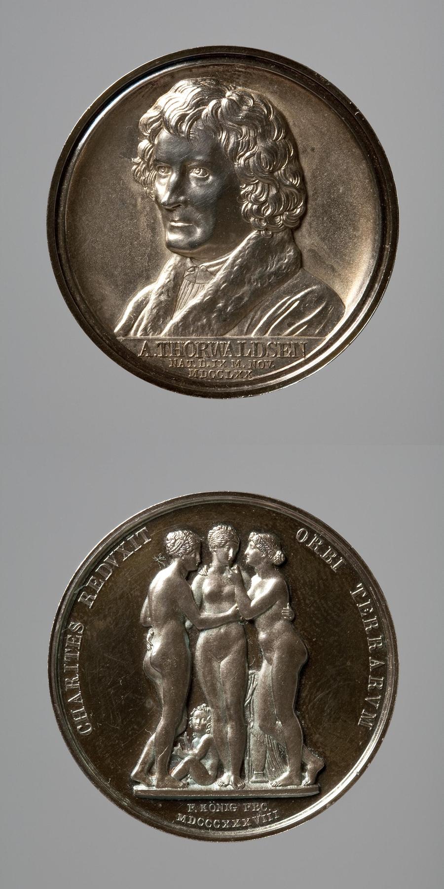 Medaljens forside: Portræt af Thorvaldsen. Medaljens bagside: Gratierne og Amor, F11